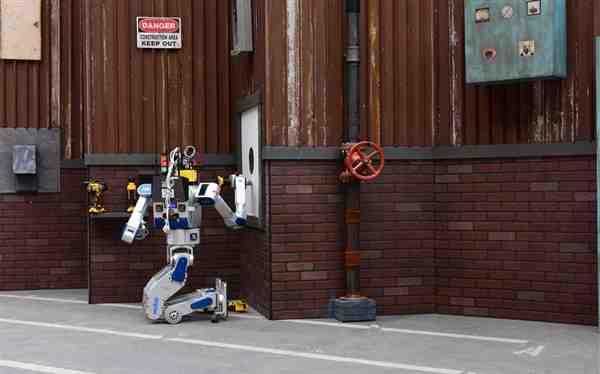 Team Kaist’s robot DRC-Hubo uses a tool to cut a hole in a wall during the DARPA Robotics Challenge Finals, June 5-6, 2015, in Pomona, Calif. Team Kaist won the top prize at the competition. DARPA photo