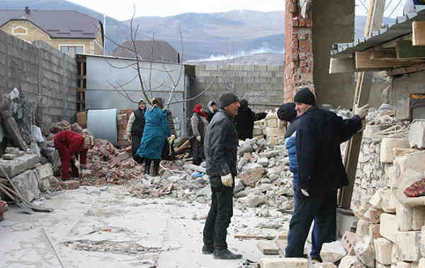 Local residents cleaning up the debris of a house destroyed in a counterinsurgency operation in Novyi Agachaul, Dagestan, February 2014.