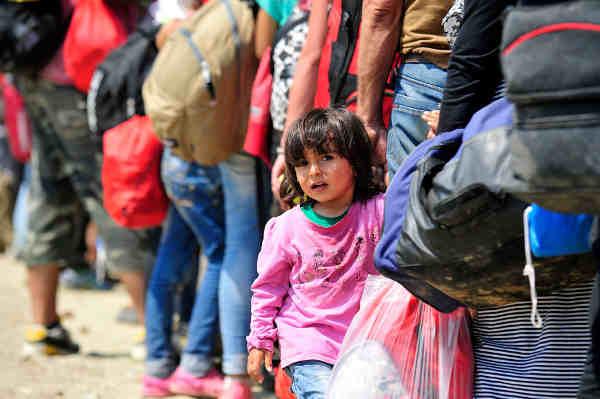Near the town of Gevgelija, former Yugoslav Republic of Macedonia, a young Syrian girl holds the hand of an adult waiting to board a train to the Serbian border. Photo: UNICEF / Tomislav Georgiev
