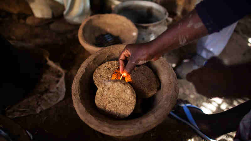 A woman fires a fuel-efficient stove made in the Rwanda camp for internally displaced people (IDPs), near Tawila, North Darfur. UN Photo / Albert González Farran