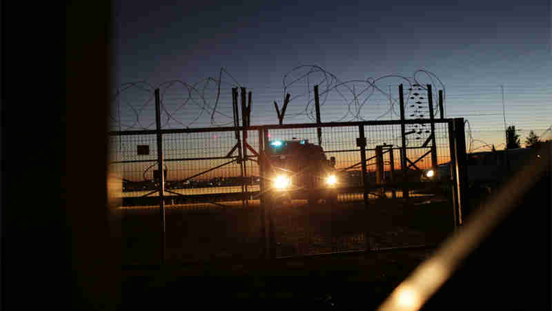 An Israeli Security Forces vehicle lights a gate in the security fence that separates farmers in the Biddu enclave from their land in the Seam Zone, which is the land between the 1949 Armistices Line and the West Bank Barrier. UN Photo: Alaa Ghosheh / UNRWA Archives