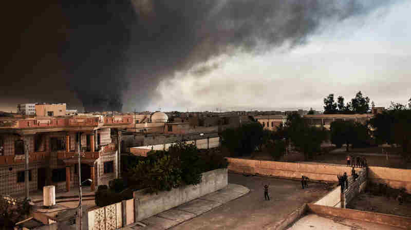 Oil wells set alight by ISIL are visible from the newly retaken Iraqi town of al-Hud, outside Mosul, where IOM distributed 350 non-food item kits to recently displaced families. UN Photo: IOM / Jennifer Sparks