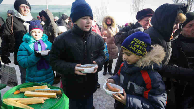 On 1 February 2017, children eat a hot meal at a heated emergency shelter in freezing cold Avdiivka, Ukraine, following intense fighting at the end of January 2017. Photo: UNICEF/Aleksey Filippov