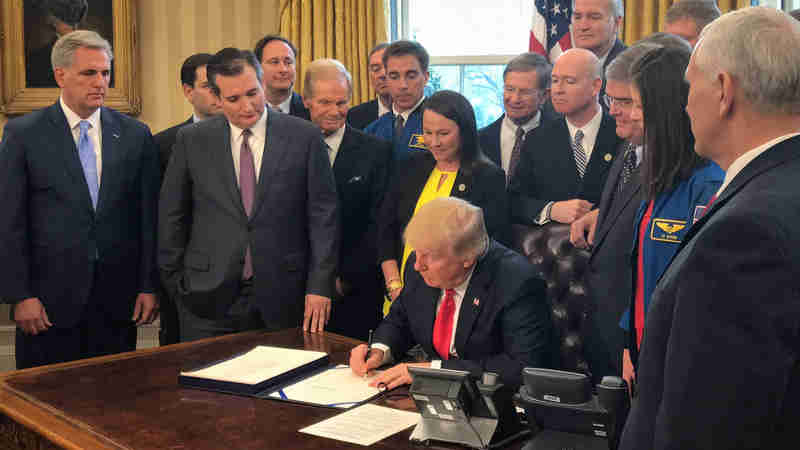 President Donald Trump, center, signs the NASA Transition Authorization Act of 2017