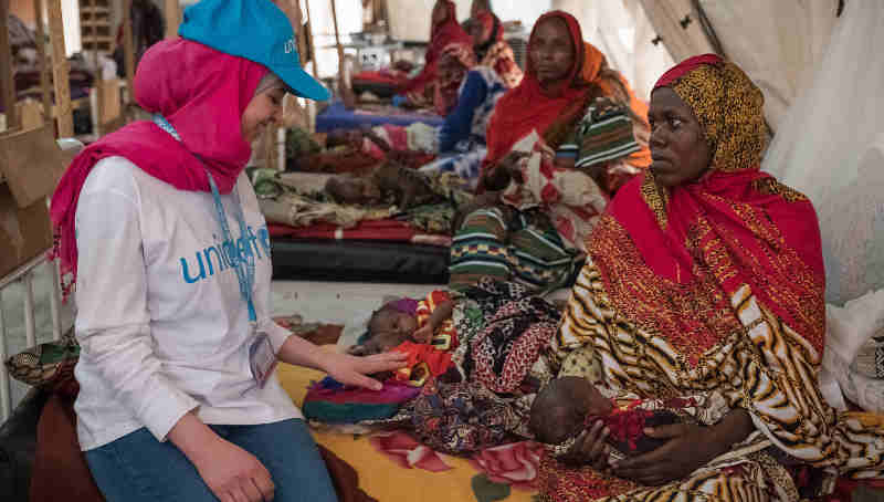 (left) Syrian refugee and education activist Muzoon Almellehan speaks with Salmata, 21, from Tala village as she sits on a bed alongside her three-week-old malnourished triplets at the nutrition ward in Bol Regional Hospital, Lake Region, Chad, Tuesday 18 April 2017.