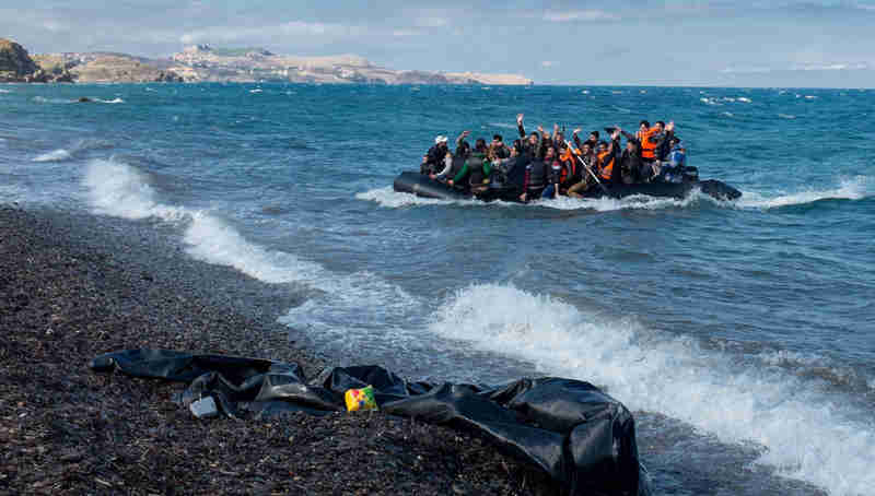 Newly arriving refugees wave and laugh as the large inflatable boat they are in approaches the shore, near the village of Skala Eressos, on the island of Lesbos, in the North Aegean region of Greece. Photo: UNICEF/Ashley Gilbertson VII