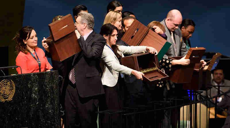 Conference officers hold up empty ballot boxes before collecting ballots from delegates. UN Photo/Manuel Elias