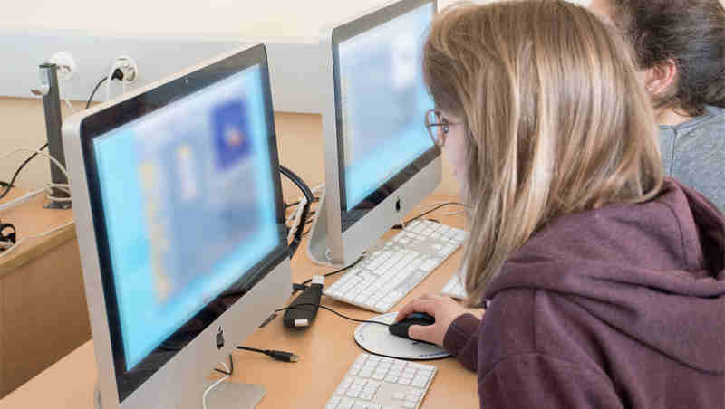 Two users browse websites on their computers (content blurred for privacy). Photo: ITU/A.Mhadhbi