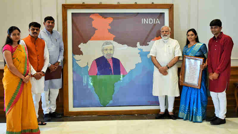 Narendra Modi being presented the artwork made with pearls by artist Khushboo Akash Davda, in New Delhi on June 15, 2017