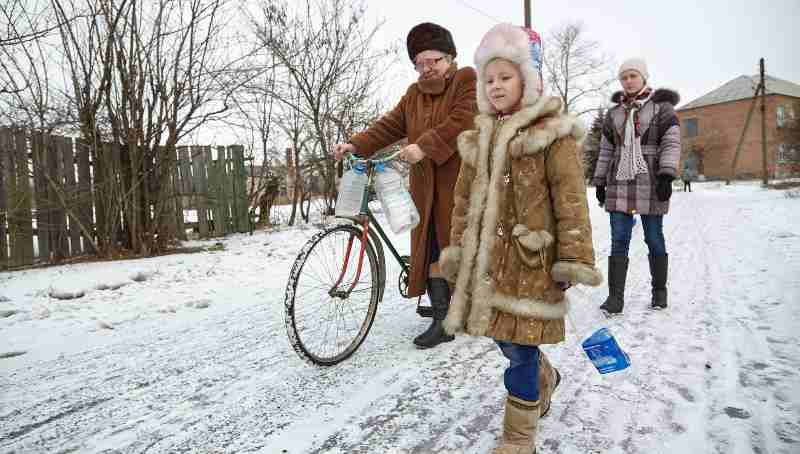 On 13 February 2017, Nina (left) and her granddaughters, Diana (right), 14, and Sasha (center), 6, leave their home to collect water from the well located on the outskirts of the village. Photo: UNICEF