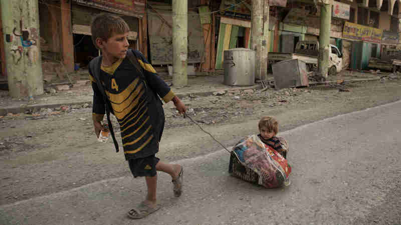 A boy pulls his sibling on a make-shift sledge outside the Old City after fleeing heavy fighting in Mosul, Iraq, Thursday 6 July 2017. Photo: UNICEF