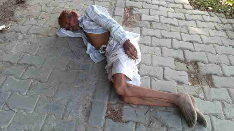 A poor sick man sleeps on the road just 100 yards away from a Mohalla Clinic which fails to provide medical treatment to patients. Photo: Rakesh Raman