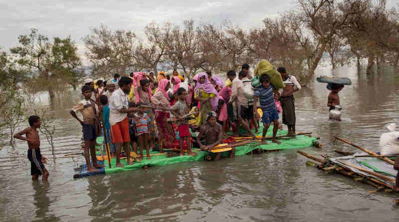 Rohingya refugees, including infants and children, on a makeshift raft made of logs, bamboo poles and jerrycans are brought to shore through the mangroves after they crossed the Naf River, which demarcates the border between Myanmar and Bangladesh, Sunday 12 November 2017. Photo: UNICEF