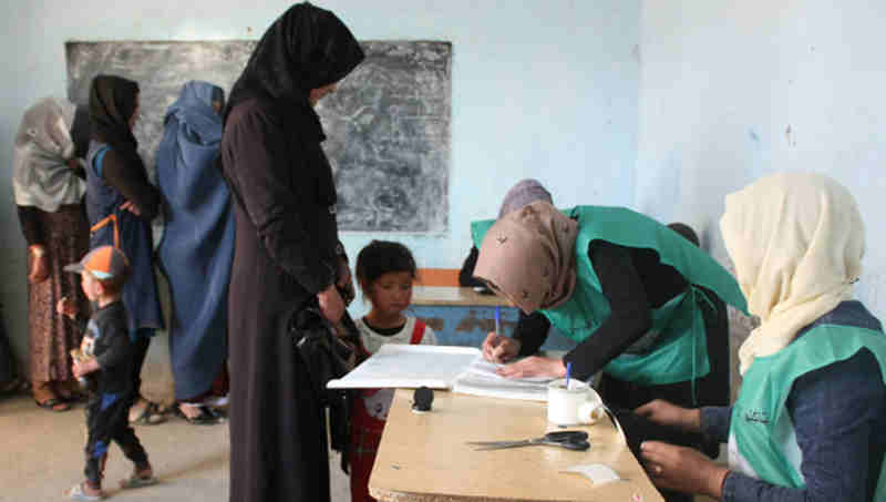 Afghan men and women register as voters at a centre in Bamyan ahead of elections in October 2018. Photo: UNAMA/Jaffar Rahim
