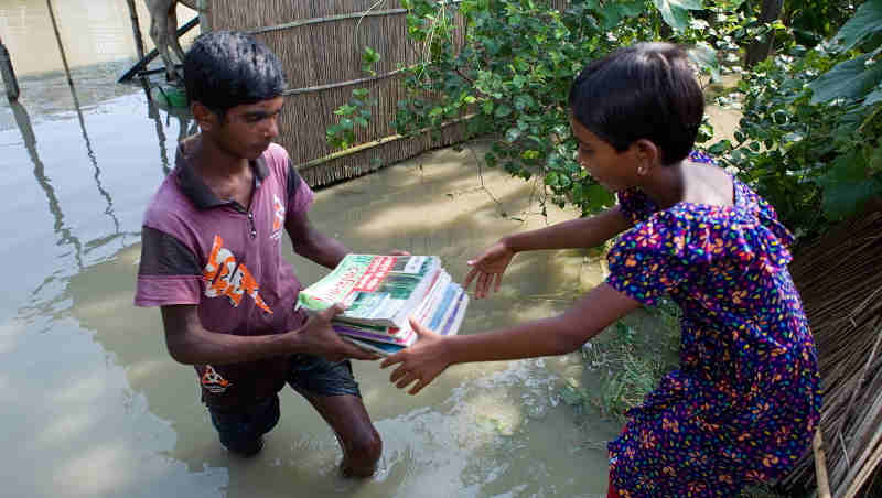 Momtaz (9) and Akobbar Hossain (15) are both residing in the village of Rajibpur, Chilmari, Kurigram which is one of the highly flood affected areas in Bangladesh. Their books got wet when water rushed into their home. Photo of 17th of July 2019. Photo: Kiron / UNICEF