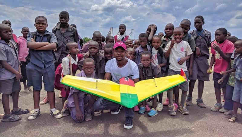 University student poses with school children at Kasungu Drone Corridor. A team of University of Malawi students, under the supervision of a team from Virginia Tech University, flew an autonomous 19 km simulated drug delivery flight in a drone. The drone was designed and built by the Malawian students. The flight testing occurred at the drone testing corridor in Kasungu. UNICEF through the Civil Aviation Authority (CAA) launched the air corridor to test potential humanitarian use of unmanned aerial vehicles (UAVs), also known as drones. The corridor is the first in Africa and one of the first globally. Drones have been used to test the feasibility of transporting laboratory samples for early infant HIV diagnosis, emergency medical supply delivery and vaccines. Photo: UNICEF