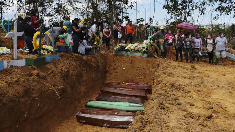 Relatives mourn at the site of a mass burial at the Nossa Senhora Aparecida cemetery, in Manaus, Amazonas state, Brazil. The cemetery is carrying out burials in common graves due to the large number of deaths from COVID-19 disease, according to a cemetery official. Photo: Edmar Barros / AP