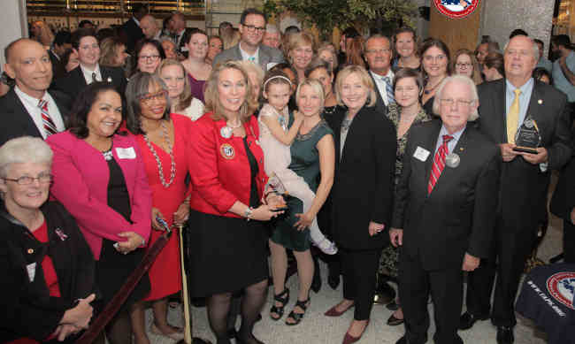 Former Secretary of State Hillary Clinton with surviving military families from TAPS, the Tragedy Assistance Program for Survivors. Secretary Clinton received the Lifetime Service Award in recognition of her support for the organization over the last decade.