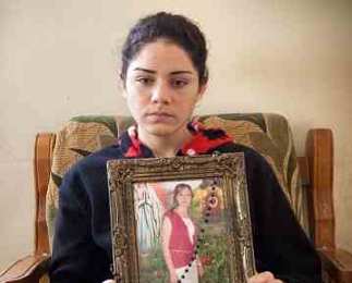 Silvana holds a picture of her sister, Sandi, who was killed by an ISIS bomb while riding the bus to university. Threatened with death by ISIS, Silvana is now in hiding.