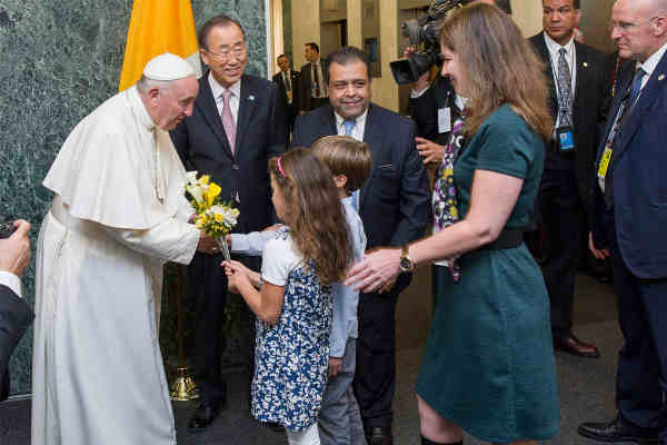 Pope Francis is welcomed by Secretary-General Ban Ki-moon and receives flower bouquets from children of UN staff members at the start of his visit to UN Headquarters. UN Photo / Mark Garten