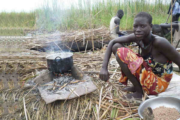 An internally displaced woman seeking refuge from the ongoing violence in the swamps of Unity state, cooks her last supply of sorghum. Photo: FAO South Sudan
