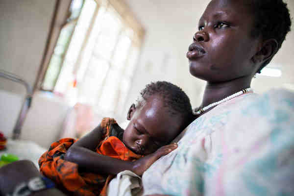 A mother holds her severely malnourished 22-month-old baby in the Al Sabah children's hospital in Juba, South Sudan, while awaiting treatment at the UNICEF-supported nutrition ward. Photo: UNICEF / Albert González Farran