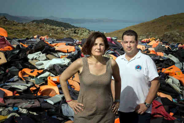 Efi Latsoudi, human rights activist behind PIKPA camp, and Hellenic Rescue Team leader Konstantinos Mitragas, in front of a vast pile of lifejackets in northern Lesvos, a haunting reminder of the dangers faced by refugees who arrived on Greek shores in 2015. Photo: UNHCR/Gordon Welters