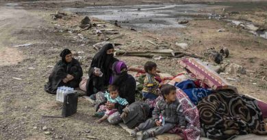 A family displaced by fighting in the village of Shora, 25 kilometres south of Mosul, wait by the roadside at an army checkpoint on the outskirts of Qayyarah. Photo: UNHCR / Ivor Prickett