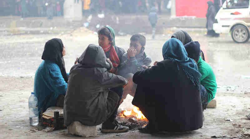 Children and their parents gather around a fire to keep warm in the yard of a large warehouse in Jibreen, now used as a shelter for thousands of families who fled violence in eastern Aleppo. Photo: UNICEF / UN043357 / Al-Issa