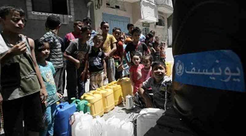 On 23 August 2014 children queue to fill jerrycans and other containers with water, at a filling station in Nuseirat, in the central Gaza Strip. Photo: UNICEF