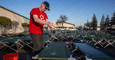 A Red Cross volunteer cleans cots outside of the Red Cross Silver Dollar Fairgrounds shelter in Chico, California.