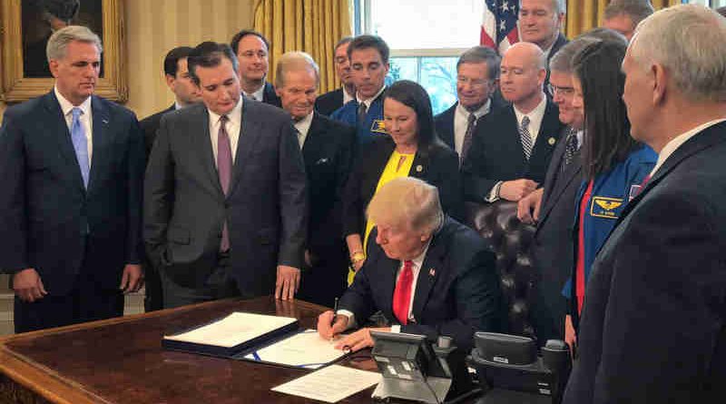 President Donald Trump, center, signs the NASA Transition Authorization Act of 2017