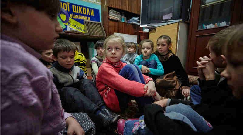 On 13 February 2017, first-grade students in eastern Ukraine, including 6-year-old Sasha (in red sweater), participate in a drill to practice their response to a shelling. Photo: UNICEF / UN053119 / Zmey