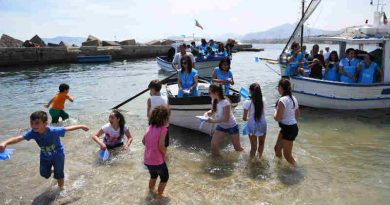 Italian Coastguard, children, volunteers and officials take part in a symbolic rescue of paper boats to send a message to the G7 leaders to take action to safeguard children on the move off a beach in Palermo, Italy, on Thursday, May 25, 2017.