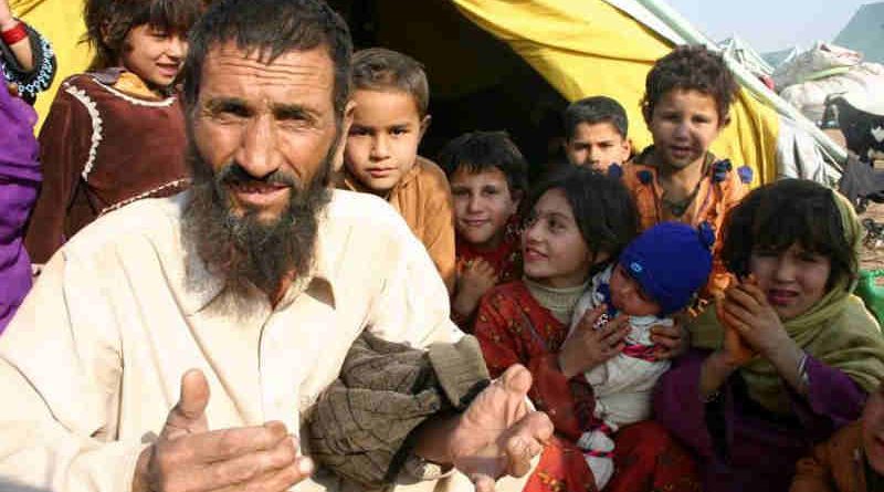 Afghan refugees sit outside their tent in Islamabad, Pakistan. Photo: UNHCR/A. Shahzad (file photo)