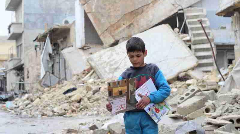 On 16 January 2017 in the Syrian Arab Republic, a child carries manuals distributed by UNICEF volunteers in the area following an informative session on identifying and reporting unexploded objects in Al- Sakhoor neighbourhood of East Aleppo.