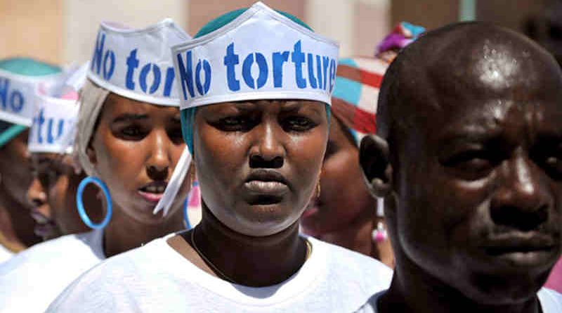 Singers wearing hats advocating "No Torture" line up before performing at a Human Rights Day event outside of Mogadishu Central Prison in Somalia. UN Photo/Tobin Jones