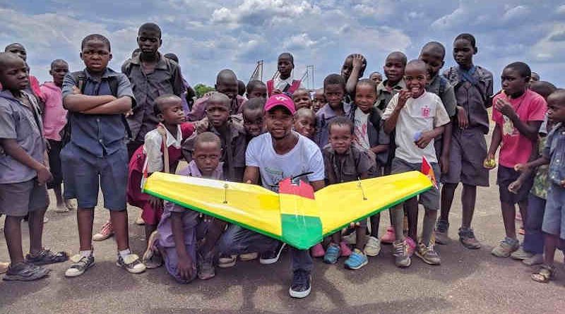 University student poses with school children at Kasungu Drone Corridor. A team of University of Malawi students, under the supervision of a team from Virginia Tech University, flew an autonomous 19 km simulated drug delivery flight in a drone. The drone was designed and built by the Malawian students. The flight testing occurred at the drone testing corridor in Kasungu. UNICEF through the Civil Aviation Authority (CAA) launched the air corridor to test potential humanitarian use of unmanned aerial vehicles (UAVs), also known as drones. The corridor is the first in Africa and one of the first globally. Drones have been used to test the feasibility of transporting laboratory samples for early infant HIV diagnosis, emergency medical supply delivery and vaccines. Photo: UNICEF