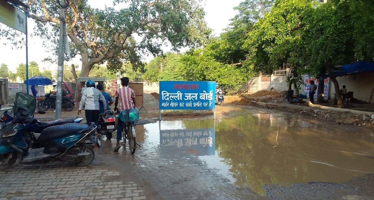 Delhi Jal Board signboard at a hazardous Dwarka sewer repair site.